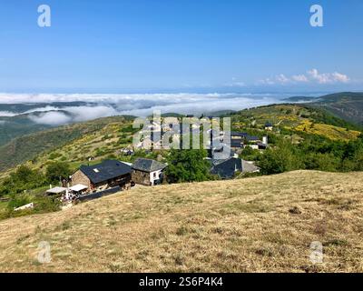 Blick auf das alte spanische Bergdorf El Acebo auf dem Camino de Frances, von Cruz de Fierro nach Molineseca. Nebel und Nebel darunter. Stockfoto