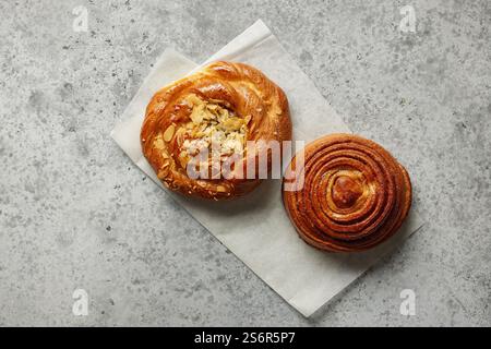 Frisch gebackene süße Brötchen auf grauem Tisch, Blick von oben Stockfoto
