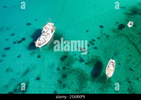 Kleine Fischerboote ankern im kristallklaren Meerwasser auf der Insel Rab, Kroatien Stockfoto