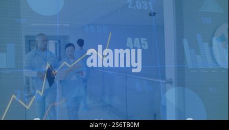 Mediziner gehen im Krankenhauskorridor mit dem Bild der Finanzdaten über Stockfoto
