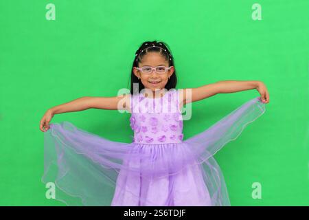 Das 5-jährige lateinische Brünette Mädchen mit Brille und Prinzessinnenkleid ist glücklich und hat Spaß beim Spielen in ihrem Urlaub Stockfoto