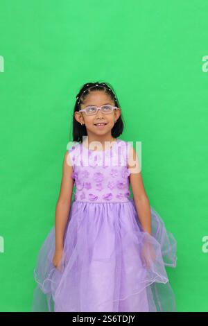Das 5-jährige lateinische Brünette Mädchen mit Brille und Prinzessinnenkleid ist glücklich und hat Spaß beim Spielen in ihrem Urlaub Stockfoto