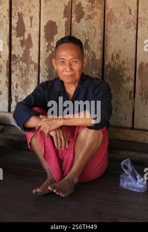 Ein älterer Karen-Mann ruht auf seiner Veranda in der Nähe von Maesot, Thailand Stockfoto