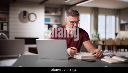 Mann, Der Steuern Und Familienbudget Am Computer Macht Stockfoto