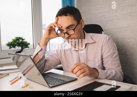 Porträt seiner schönen, attraktiven, fokussierten, professionellen Kerl, der Programmierung von Webseiten ferngesteuert an modernen Arbeitsplätzen unterstützt. Der junge Mann Stockfoto