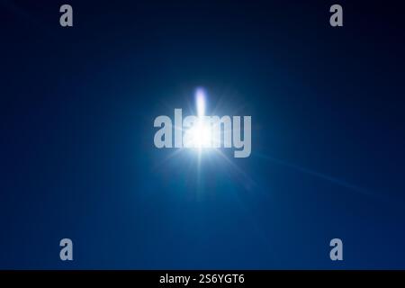Linseneffekt der Sonne über tiefblauem Himmel, Hintergrundfotografie Stockfoto