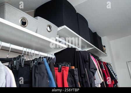 Organisierter Kleiderschrank mit Tüchern und Regalboxen oben Stockfoto
