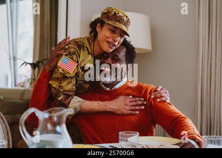 US-Veteranin Frau Homecoming. Eine junge Frau, die aus dem Militärdienst zu ihrer Familie zurückkehrt. Soldatinnen, die nach Hause gehen, um Zeit mit ihr zu verbringen Stockfoto