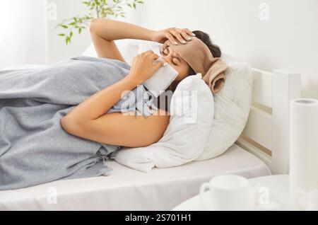 Kranke Frau, Die Im Bett Liegt Und Zu Hause Niest Stockfoto