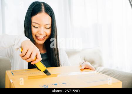 Eine Frau hält einen Universalschneider für präzises Auspacken und enthüllt Online-Shopping-Inhalte Stockfoto