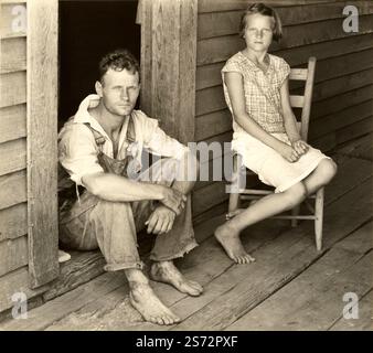 1936 , HALE COUNTY , ALABAMA , USA : The Poor FLOYD BURROUGHS , Cotton Farerecropper , während der Wirtschaftskrise der Großen amerikanischen Depression . Fotografiert auf den Stufen der Verandschwelle am Eingang zu seinem Landhaus mit Tochter LUCILLE BURROUGHS. Foto des großen Künstlers WALKER EVANS ( 1903–1975), Mitarbeiter der United States Agricolture Farm Security Administration oder Office of war Information Inlandshofs, als Werk der US-Bundesregierung. - STATI UNITI AMERICA - bellezza maschile - männliche Schönheit - Porträt - ritratto - UOMO - Stockfoto