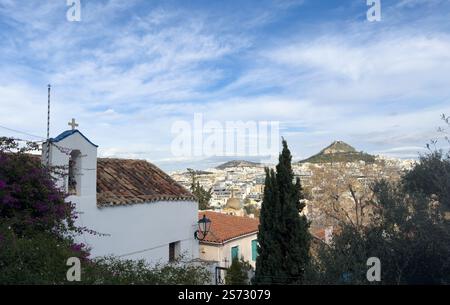 Kleine weiße Kapelle und Stadtbild von Athen mit dem Lycabettus-Berg, Blick vom Akropolis-Hügel in Griechenland, blauer Himmel mit Wolken Stockfoto