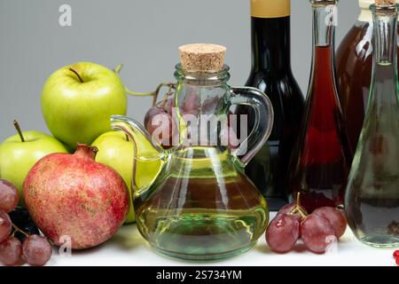 Verschiedene Arten von Essig Apfel, Wein und Granatapfel in Essigschalen unter Früchten. Stockfoto