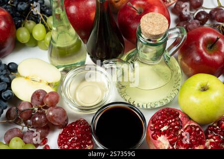 Verschiedene Arten von Essig Apfel, Balsamico, Wein und Granatapfel in Essigschalen unter Früchten. Stockfoto