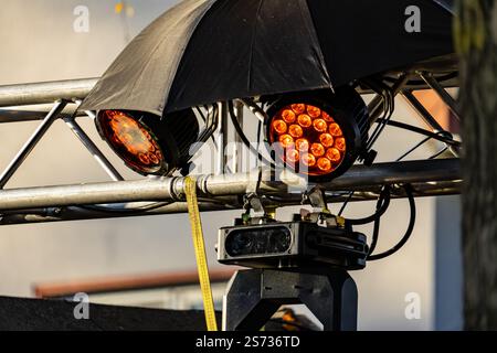 Ein schwarzer Regenschirm bedeckt zwei Lichter. Der Schirm bedeckt die Lichter und ist nicht sichtbar Stockfoto