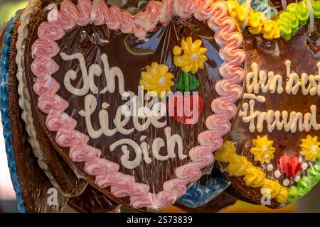 Eine Ausstellung herzförmiger Kekse mit der Aufschrift „Ich Liebe dich“. Die Kekse sind mit Zuckerguss dekoriert und hängen an einer Straße Stockfoto