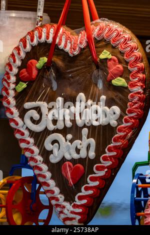 Ein herzförmiger Keks mit den Worten „Ich liebe dich“ drauf. Der Keks ist mit Zuckerguss bedeckt und hat ein rot-weißes Design Stockfoto