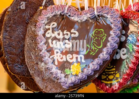 Eine Reihe von herzförmigen Schokoladen-Keksen mit der Aufschrift „Lass uns feiern“ mit weißer Tinte Stockfoto