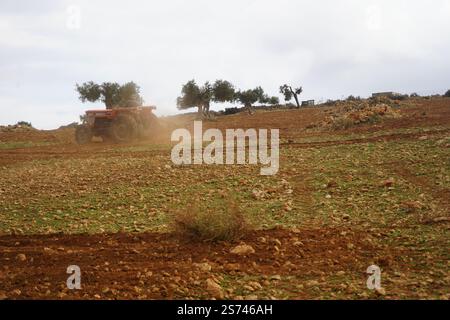 Ein alter Landwirt auf einem Traktoranbaufeld - Pflügen von Boden auf Bauernhof - ländliche Landschaft Hintergrund - Landwirtschaft Business Industriekonzept Stockfoto