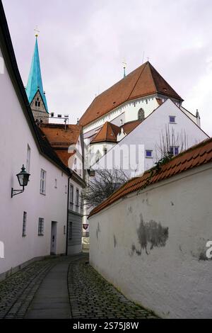 Hellblauer Turm und Kirche am Ende einer engen Gasse mit weiß getünchten Häusern auf beiden Seiten der Straße Stockfoto