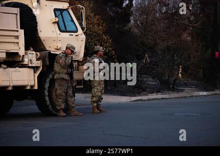 Altadena, Kalifornien, USA. Januar 2025. Mitglieder der Nationalgarde stehen neben einer verbrannten Struktur und erzwingen eine Ausgangssperre in Altadena, Kalifornien Der Gouverneur des Bundesstaates Gavin Newsom gab am 11. Januar bekannt, dass über 1600 Mitglieder der Nationalgarde als Reaktion auf das Eaton-Feuer und das Palisades-Feuer im Los Angeles County mobilisiert wurden. Quelle: Sarah Nachimson/Alamy Live News Stockfoto