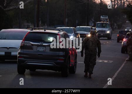 Altadena, Kalifornien, USA. Januar 2025. Ein Mitglied der Nationalgarde erzwingt eine Ausgangssperre in Altadena, Kalifornien, am Rande des Eaton-Feuers am Samstag, den 18. Januar. Der Gouverneur des Bundesstaates Gavin Newsom gab am 11. Januar bekannt, dass über 1600 Mitglieder der Nationalgarde als Reaktion auf das Eaton-Feuer und das Palisades-Feuer im Los Angeles County mobilisiert wurden. Quelle: Sarah Nachimson/Alamy Live News Stockfoto