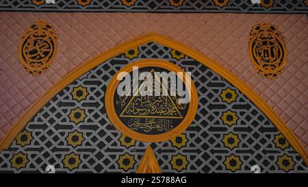 Islamische geometrische Kunst mit arabischer Kalligrafie in einem Moscheeinnenraum. Stockfoto