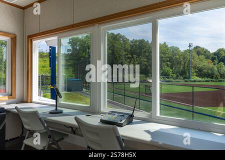 Das Innere eines Pressekastens mit einem Mikrofon mit einigen von einem synthetischen Rasen-Baseballfeld. Stockfoto