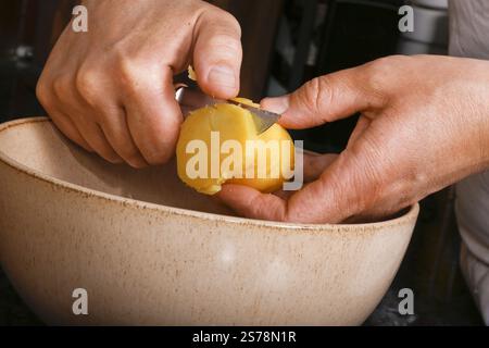 Schwäbische Küche, Zubereitung von schwäbischem Kartoffelsalat mit Stuttgarter Leberkaes in Meerrettich-Senfüberzug, Schneiden gekochter Kartoffeln, Reiben, ja Stockfoto
