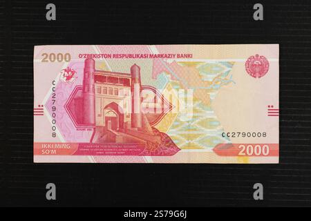 Usbekistan 2000 so’m Banknote mit Buchara Arch, Karawanenrouten auf der Karte Usbekistans, Honatlas-Textilmustern und Staatsemblem von Usbekistan po Stockfoto