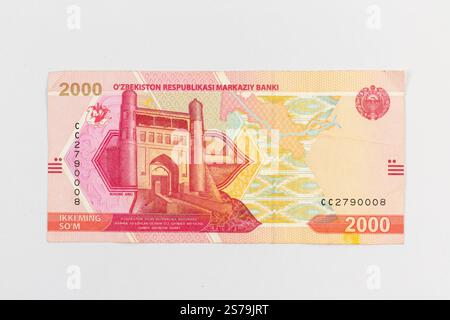 Usbekistan 2000 so’m Banknote mit Buchara Arch, Karawanenrouten auf der Karte Usbekistans, Honatlas-Textilmustern und Staatsemblem von Usbekistan po Stockfoto