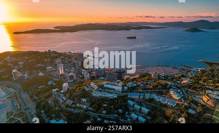 Blick aus der Vogelperspektive auf Fairfax Harbour in Port Moresby bei einem goldenen Sonnenuntergang mit einem Frachtschiff in der Bucht Stockfoto