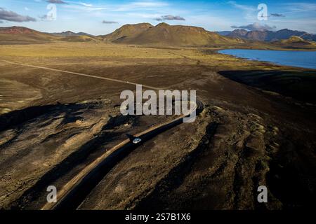 Panoramablick auf die Bergstraße F347 mit dem Auto nach Landmannalaugar, den Rainbow Mountains in Island. Berge und See im Hintergrund Stockfoto