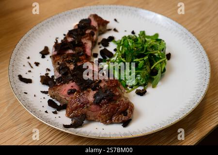 Tagliata di Manzo al Tartufo Rindersteak mit Trüffeln serviert mit grünem Rocket- oder Arugula-Salat Stockfoto