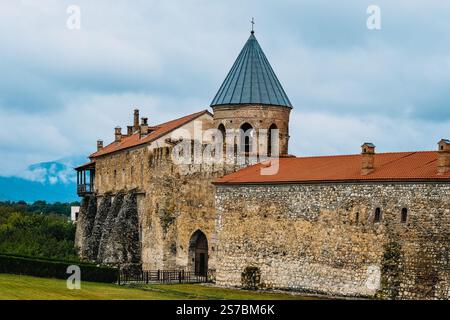 Alte Steinmauern und ein Glockenturm des Alaverdi-Klosters in Kakheti, Georgien. Eine historische orthodoxe Stätte, umgeben von Grün und Bergen Stockfoto