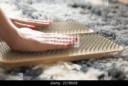 Die Frau legte ihre Hände zur Meditation auf das Brett des Sadhu. Yoga-Kurs Stockfoto