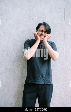 Ein Mann, der Ärger und Frustration ausdrückt und seine Ohren bedeckt. Stockfoto