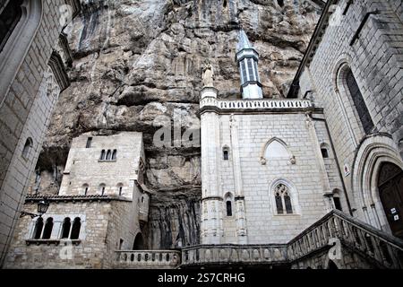 Rocamadour bietet atemberaubende Architektur an den Klippen inmitten von üppigem Grün und dramatischem Himmel, reich an Geschichte. Stockfoto