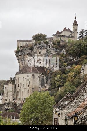 Rocamadour bietet atemberaubende Architektur an den Klippen inmitten von üppigem Grün und dramatischem Himmel, reich an Geschichte. Stockfoto