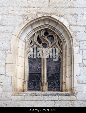 Das atemberaubende gotische Fenster zeigt komplexe Mauerwerke und Buntglas in der historischen Architektur von Rocamadour. Stockfoto