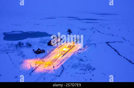 Luftaufnahme von der Drohne bei Nacht des Bahnhofs Corrour im Schnee bei Nacht im schottischen Hochland, Schottland, Großbritannien Stockfoto