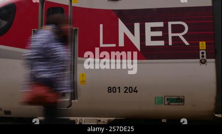 Am Bahnhof Kings Cross in London läuft ein Pendler an einem LNER Azuma-Zug vorbei Stockfoto