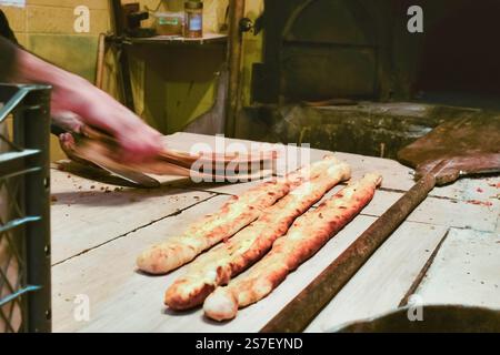 Traditionelles türkisches Essen frisch zubereitetes heißes Pide in einer lokalen Bäckerei. PIDE ist das berühmte gebackene türkische Fladenbrot, das mit verschiedenen Belägen gefüllt wird Stockfoto