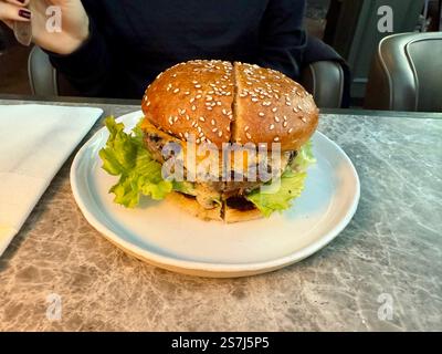 Hamburger Cheeseburger serviert mit Teller im Restaurant. Bereit zum Essen Stockfoto