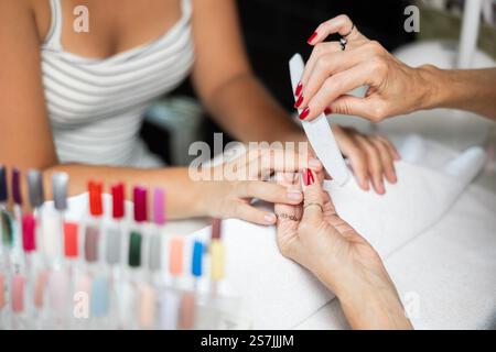 Maniküre, die Klientennägel am Tisch feilt, Nahaufnahme. Spa-Behandlung Stockfoto