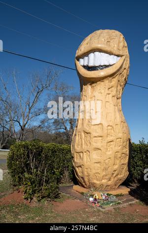 Die „lächelnde Erdnuss“ mit Blumen an der Basis, eine skurrile Skulptur zu Ehren von Präsident Jimmy Carter und seinem großen Grinsen und einst Erdnussbauern. Stockfoto