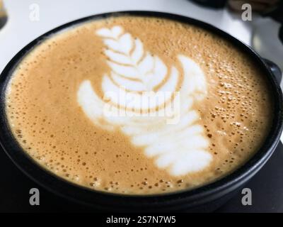 Nahaufnahme eines Latte Art Designs mit einem zarten Blattmuster in einem cusco Coffee Shop, das die Fähigkeiten des Barista zum Ausdruck bringt Stockfoto