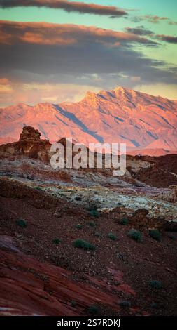 Bei Sonnenuntergang leuchtet Nevadas Valley of Fire, während das karmesinrote Licht seine zerklüfteten Berge und feurigen Sandsteinformationen erleuchtet Stockfoto