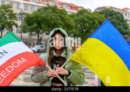Eine Frau hält während eines Protestes zwei Flaggen, eine der Ukraine und eine andere des Iran. Sie protestiert gegen die Morde im Iran nach dem Tod von Mahsa Stockfoto