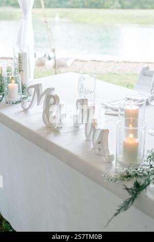 Lieblingstisch bei der Hochzeit im Freien mit weißer Bettwäsche und Kerzen. Stockfoto